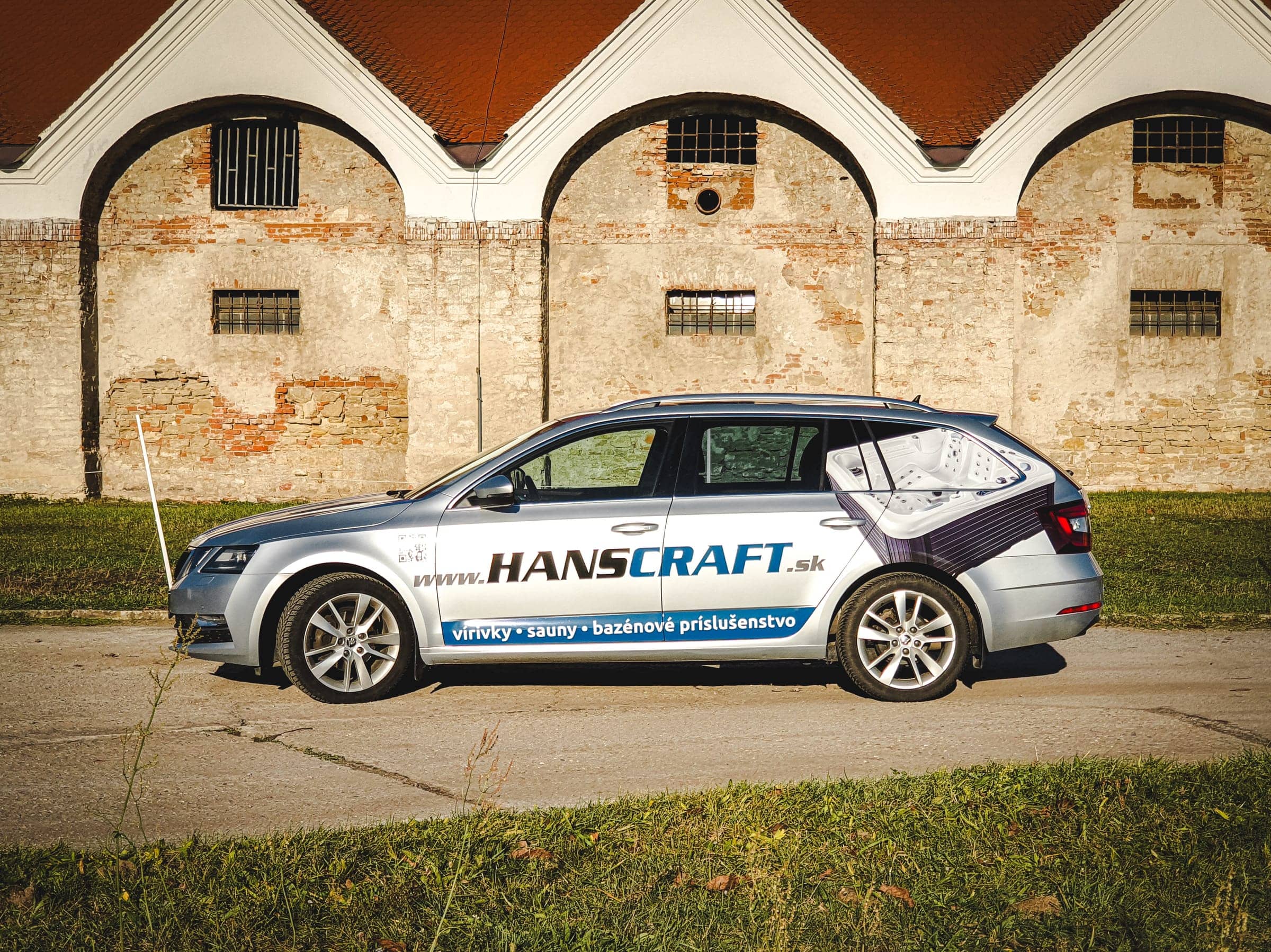 Strieborná Škoda Octavia Combi s polepom Hanscraft – vírivky, sauny – pred historickými klenbami